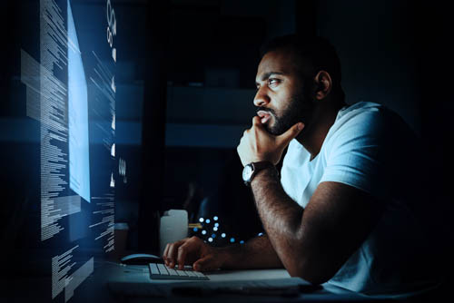 Image of a man with hands on his chin, staring at a screen