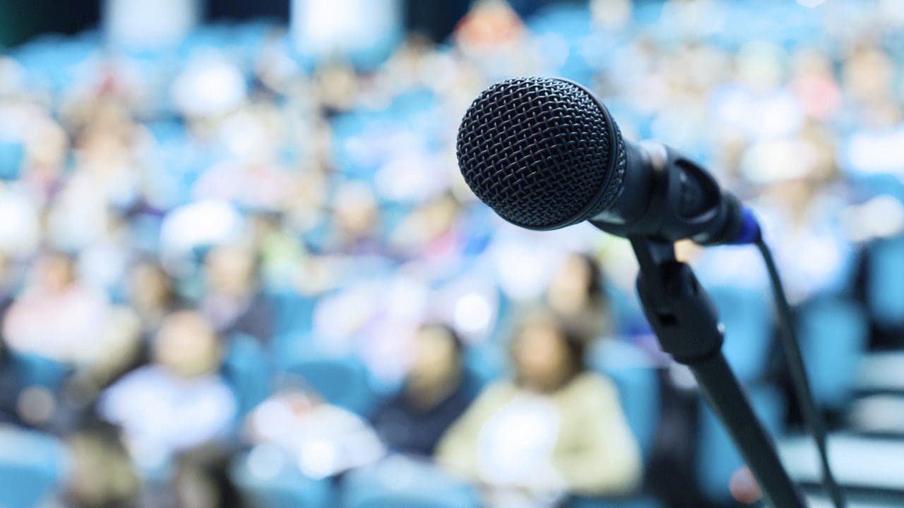 Image of a microphone in a blurred lecture hall