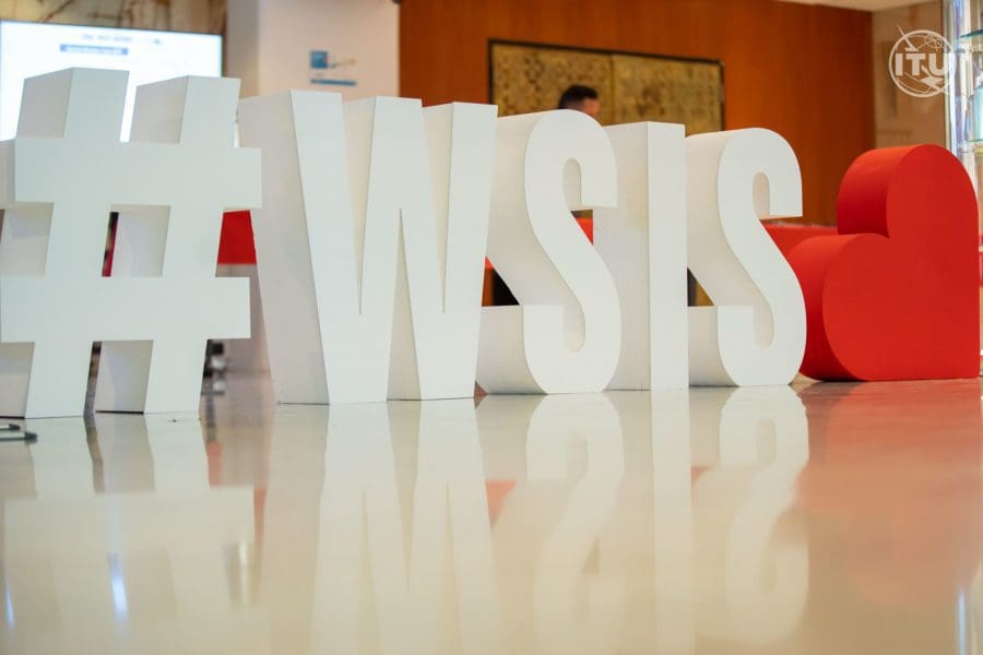 Large decorations shaped like letters, spelling #WSIS with a red heart. They are in the middle of a conference room.