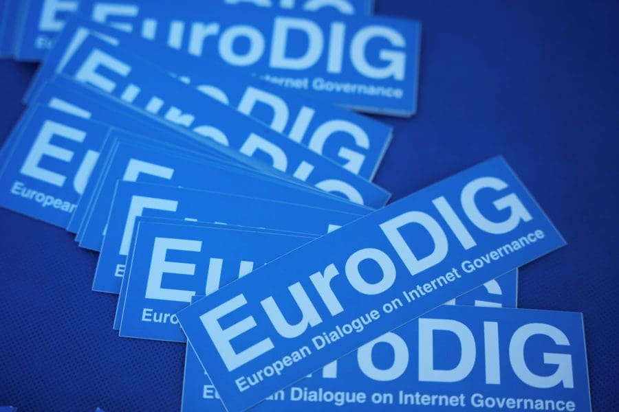 Pile of stickers on a table reading "EuroDIG European Dialogue on Internet Governance"
