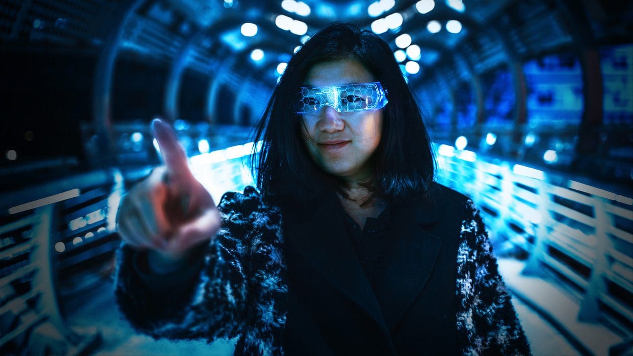 Woman with virtual reality goggles on, pointing at something.