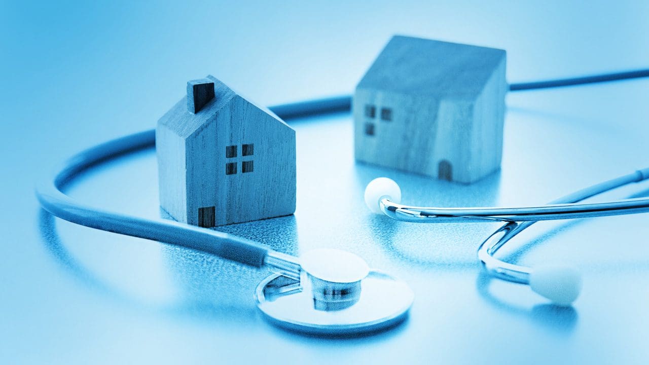 Mini blue houses with stethoscope