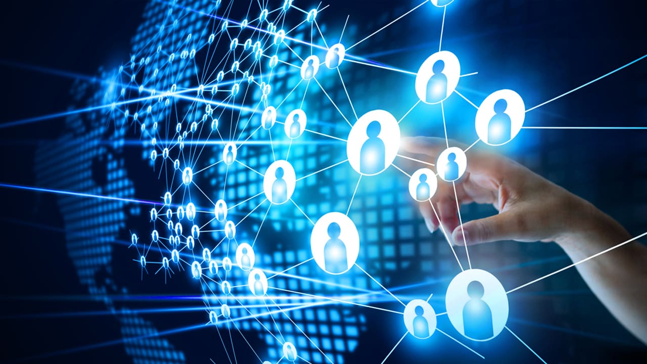 A hand touching icons connecting people around the world.