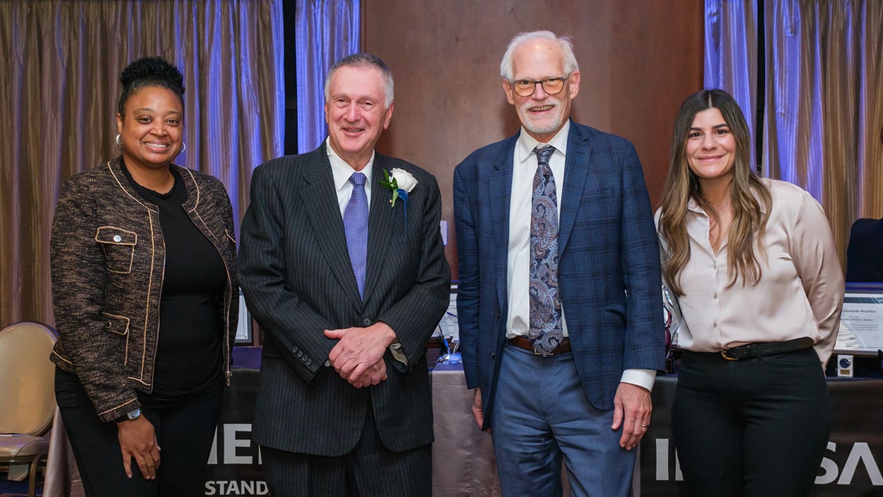 Four IEEE SA Awards attendees posing for a photo.