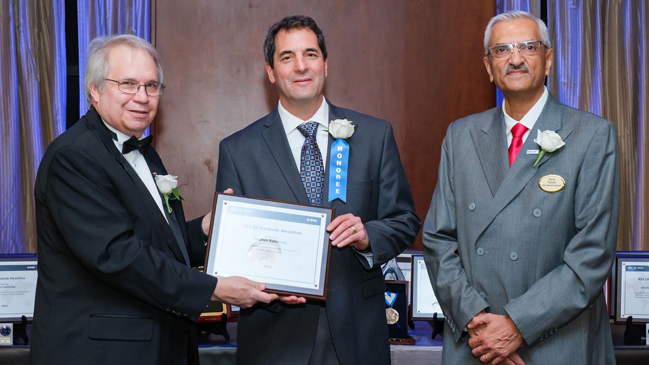 IEEE SA President Jim Matthews and Yatin Trivedi posing for a photo with an IEEE SA Awards honoree.