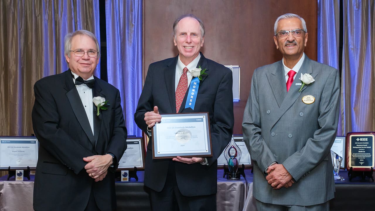 IEEE SA President Jim Matthews and Yatin Trivedi posing for a photo with an IEEE SA Awards honoree.