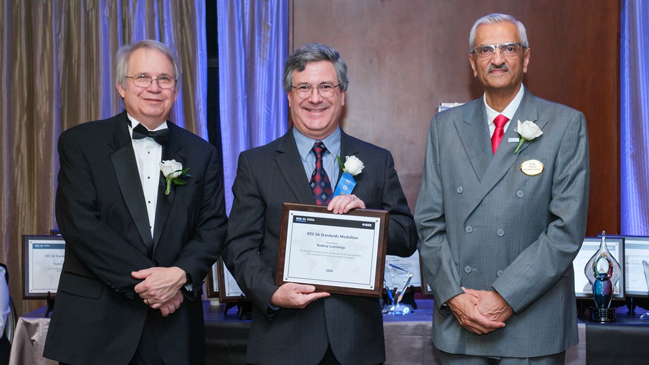 IEEE SA President Jim Matthews and Yatin Trivedi posing for a photo with an IEEE SA Awards honoree.