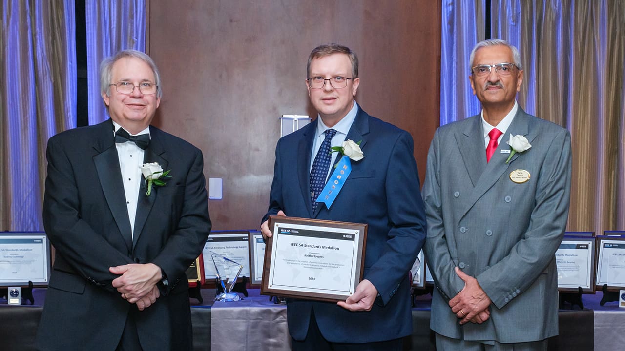 IEEE SA President Jim Matthews and Yatin Trivedi posing for a photo with an IEEE SA Awards honoree.