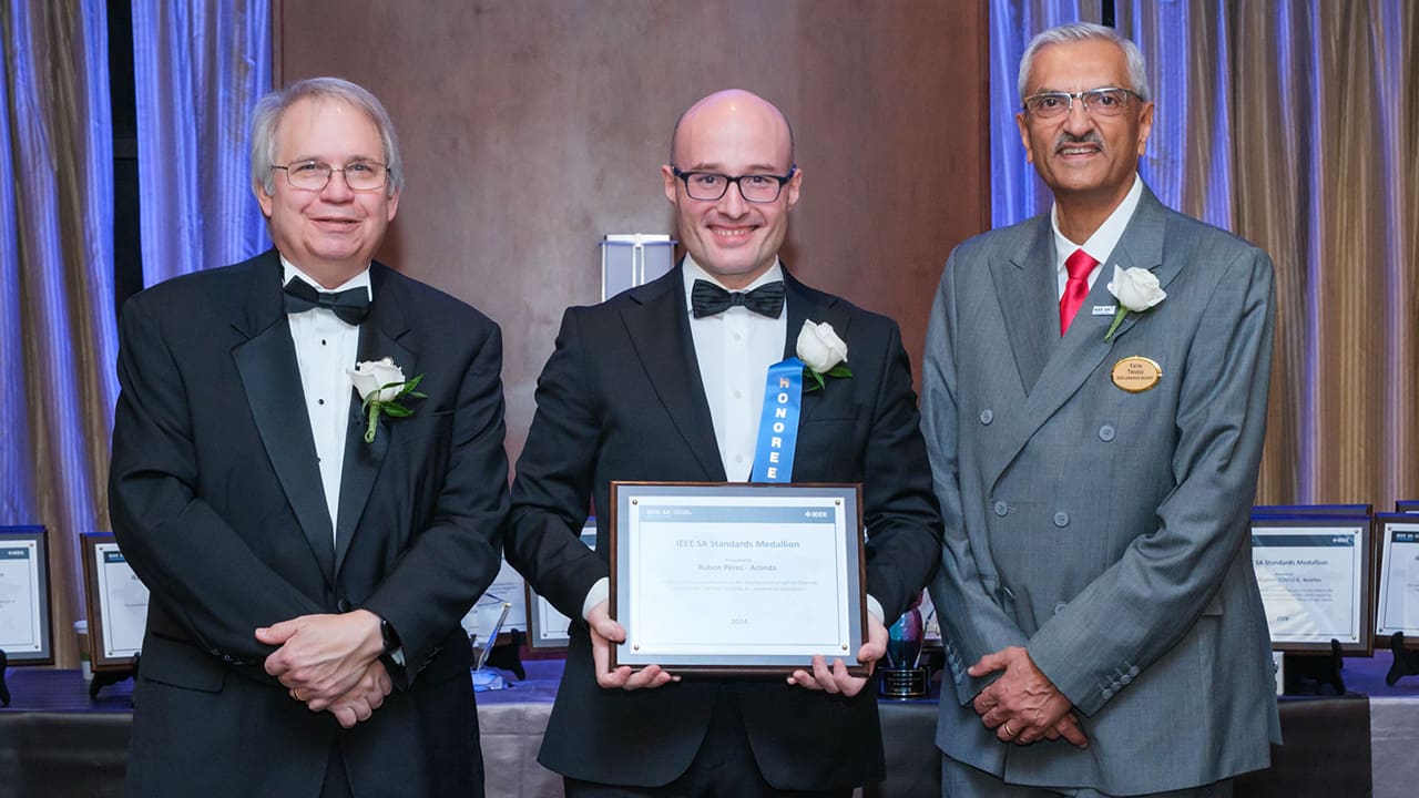 IEEE SA President Jim Matthews and Yatin Trivedi posing for a photo with an IEEE SA Awards honoree.