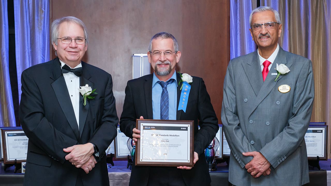 IEEE SA President Jim Matthews and Yatin Trivedi posing for a photo with an IEEE SA Awards honoree.