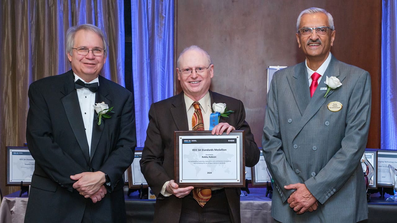 IEEE SA President Jim Matthews and Yatin Trivedi posing for a photo with an IEEE SA Awards honoree.