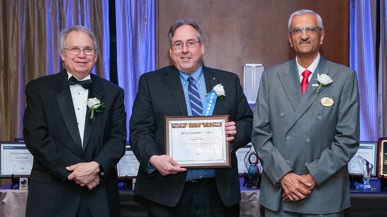 IEEE SA President Jim Matthews and Yatin Trivedi posing for a photo with an IEEE SA Awards honoree.