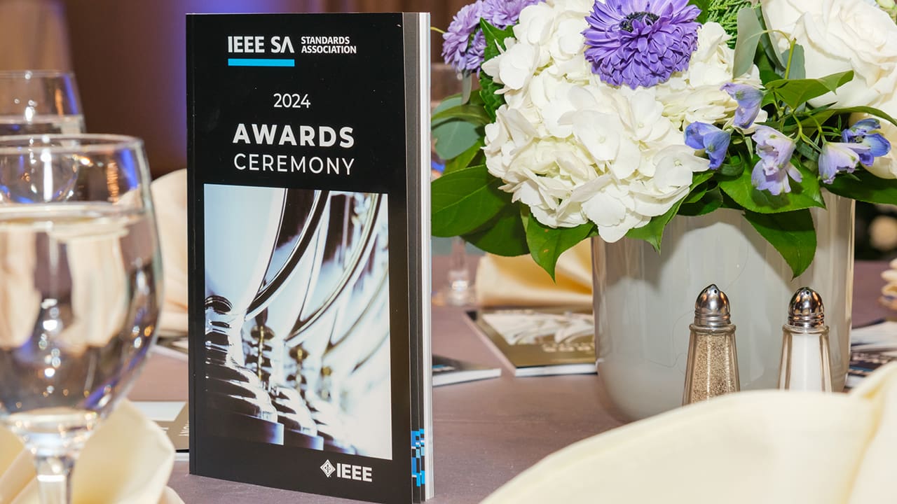 The 2024 IEEE SA Awards program book displayed on a table.