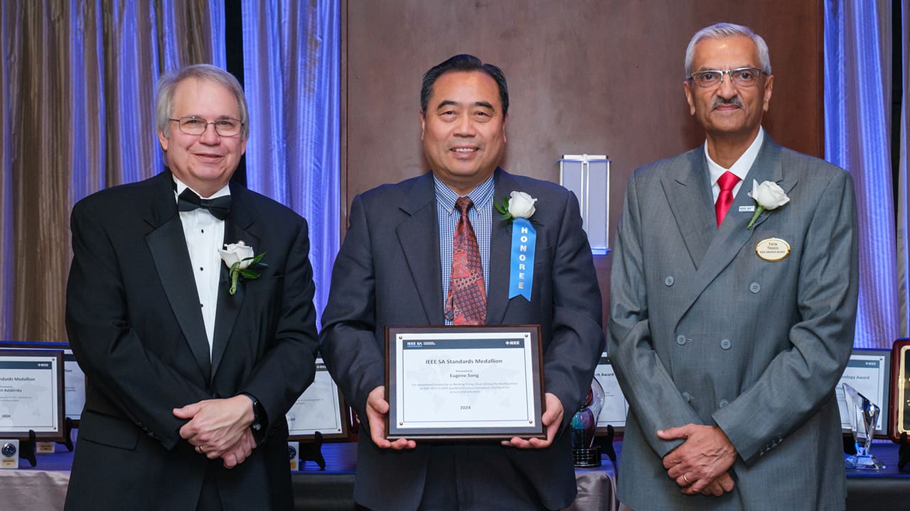 IEEE SA President Jim Matthews and Yatin Trivedi posing for a photo with an IEEE SA Awards honoree.