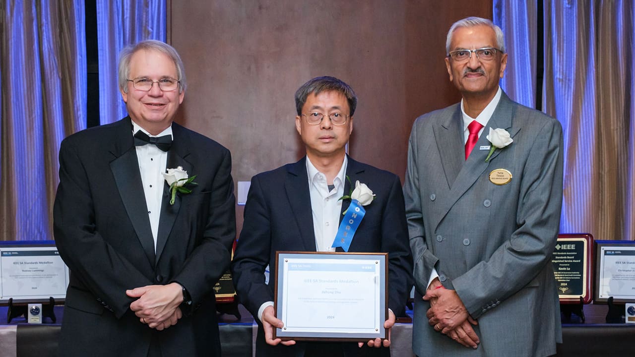 IEEE SA President Jim Matthews and Yatin Trivedi posing for a photo with an IEEE SA Awards honoree.