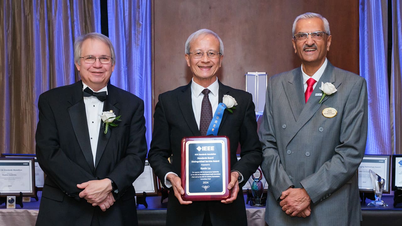 IEEE SA President Jim Matthews and Yatin Trivedi posing for a photo with an IEEE SA Awards honoree.