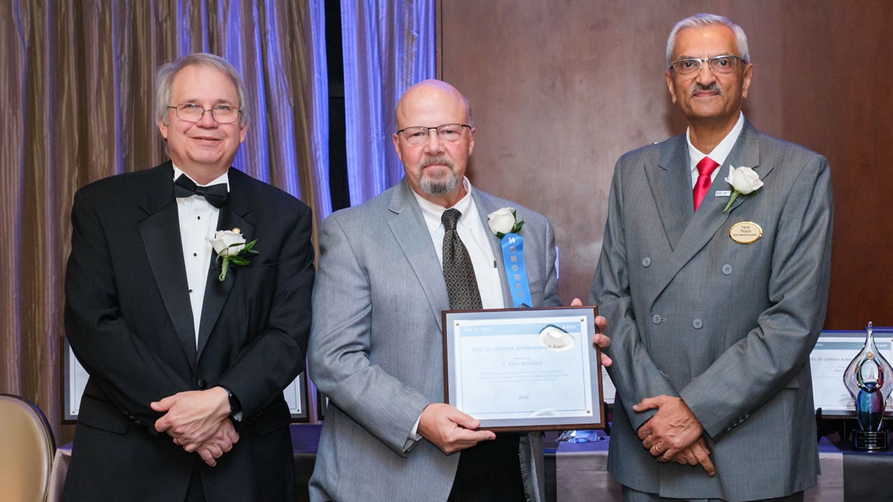 IEEE SA President Jim Matthews and Yatin Trivedi posing for a photo with an IEEE SA Awards honoree.