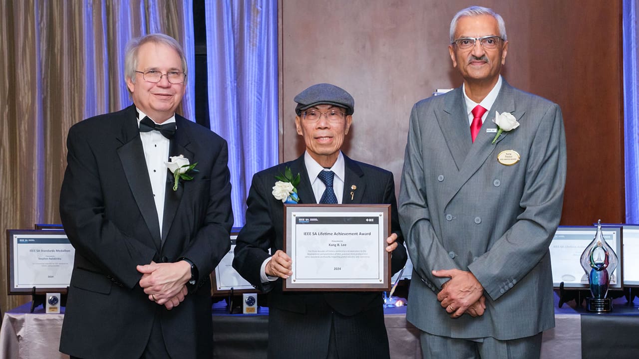 IEEE SA President Jim Matthews and Yatin Trivedi posing for a photo with an IEEE SA Awards honoree.