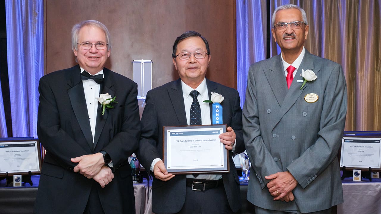 IEEE SA President Jim Matthews and Yatin Trivedi posing for a photo with an IEEE SA Awards honoree.