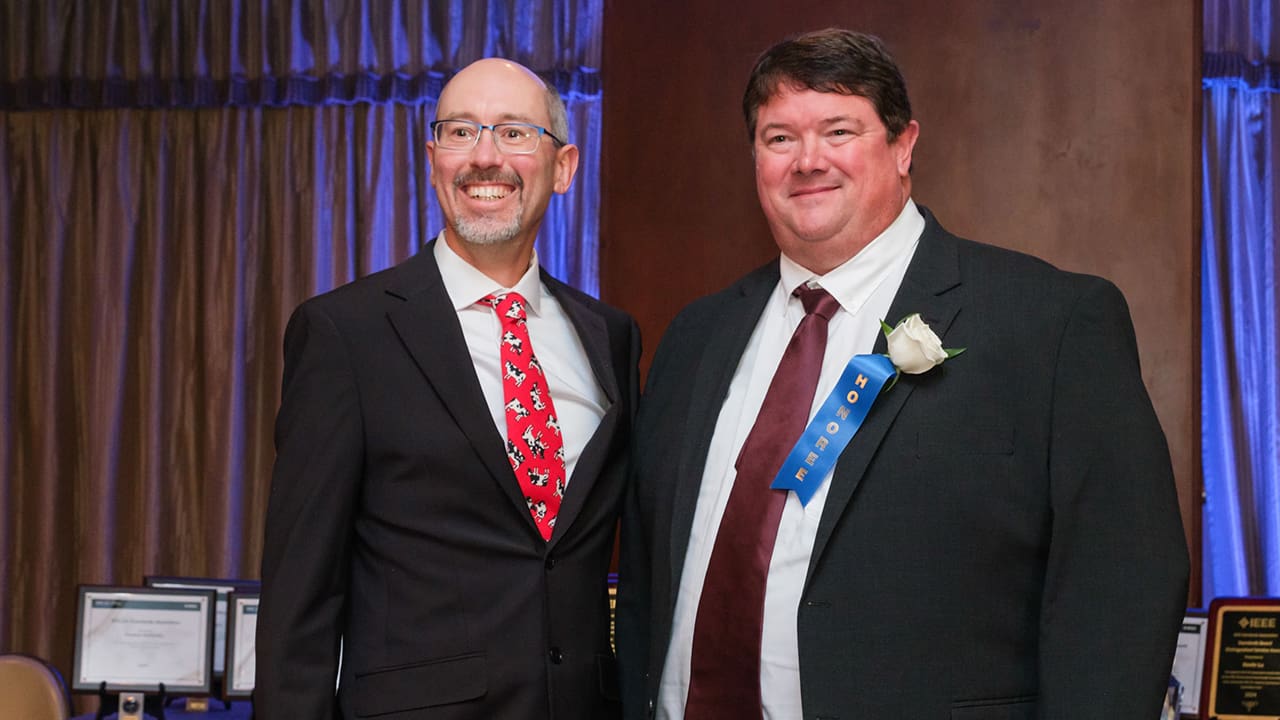 Two IEEE SA Awards attendees posing for a photo.