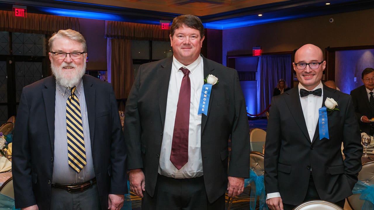 Three IEEE SA Awards attendees posing for a photo.