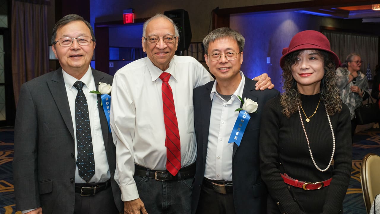 Four IEEE SA Awards attendees posing for a photo.